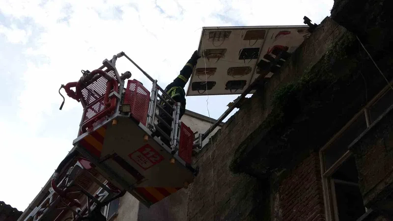 Çatıdan tehlikeli şekilde sarkan pano, itfaiye ekiplerince kaldırıldı
