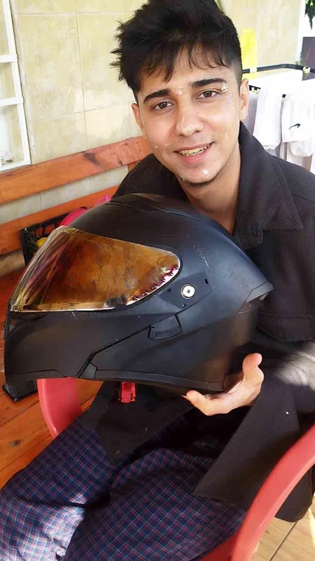 Kaskla yaşama tutunan motosikletli genç: 